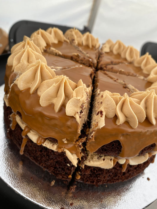 A delicious vegan Biscoff cake layered with creamy Biscoff frosting and topped with a drizzle of caramelized Biscoff spread and crumbled Biscoff cookies.