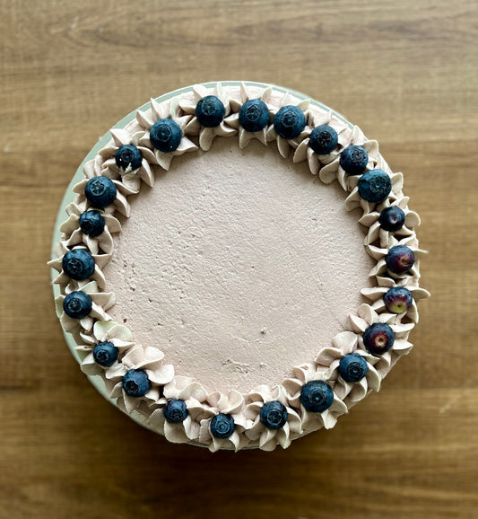 A delicious vegan blueberry cake, topped with fresh blueberries.