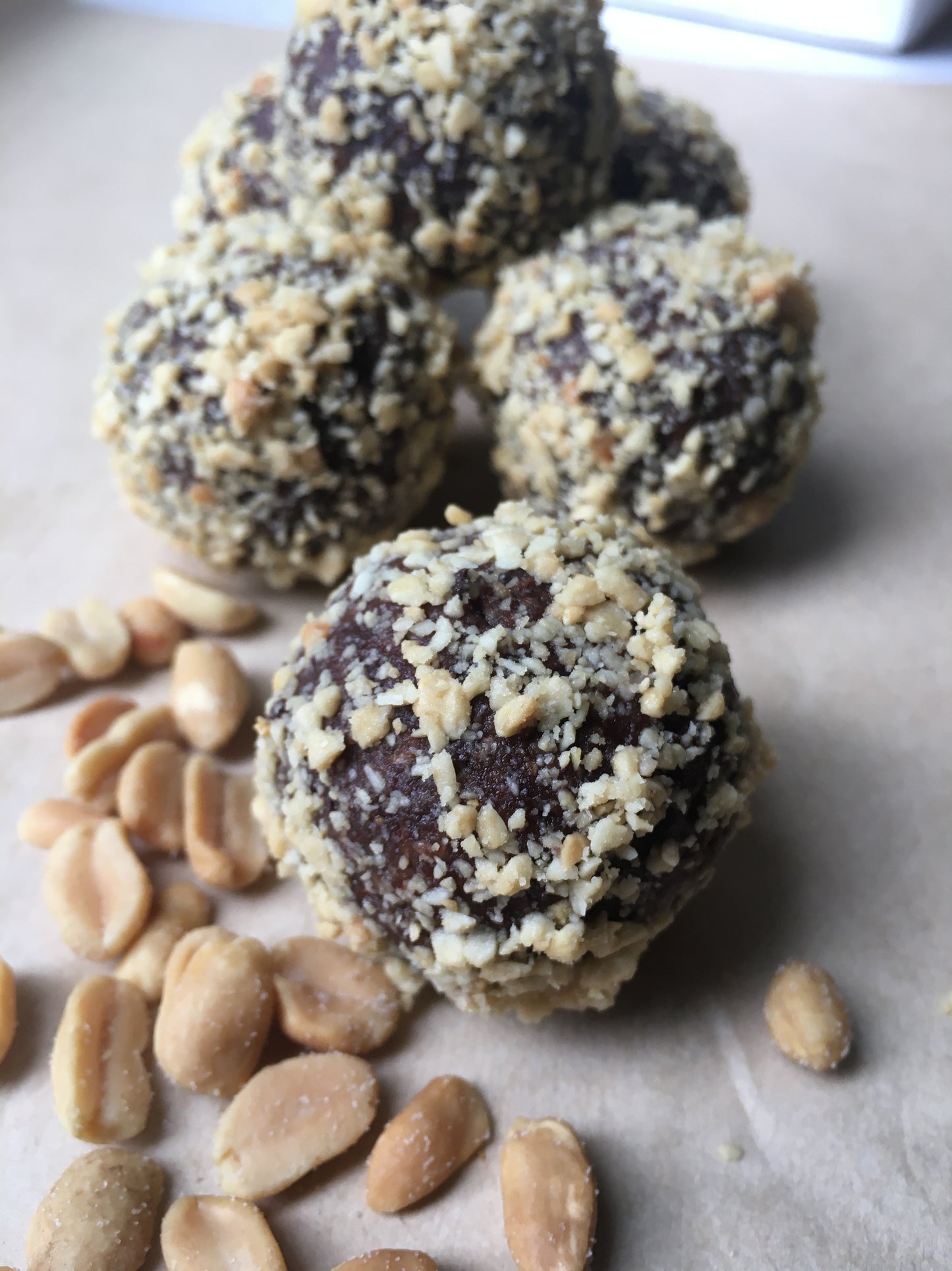 A close-up of a vegan peanut butter energy ball, showing its round shape and textured surface made with oats, peanut butter, and chocolate chips.