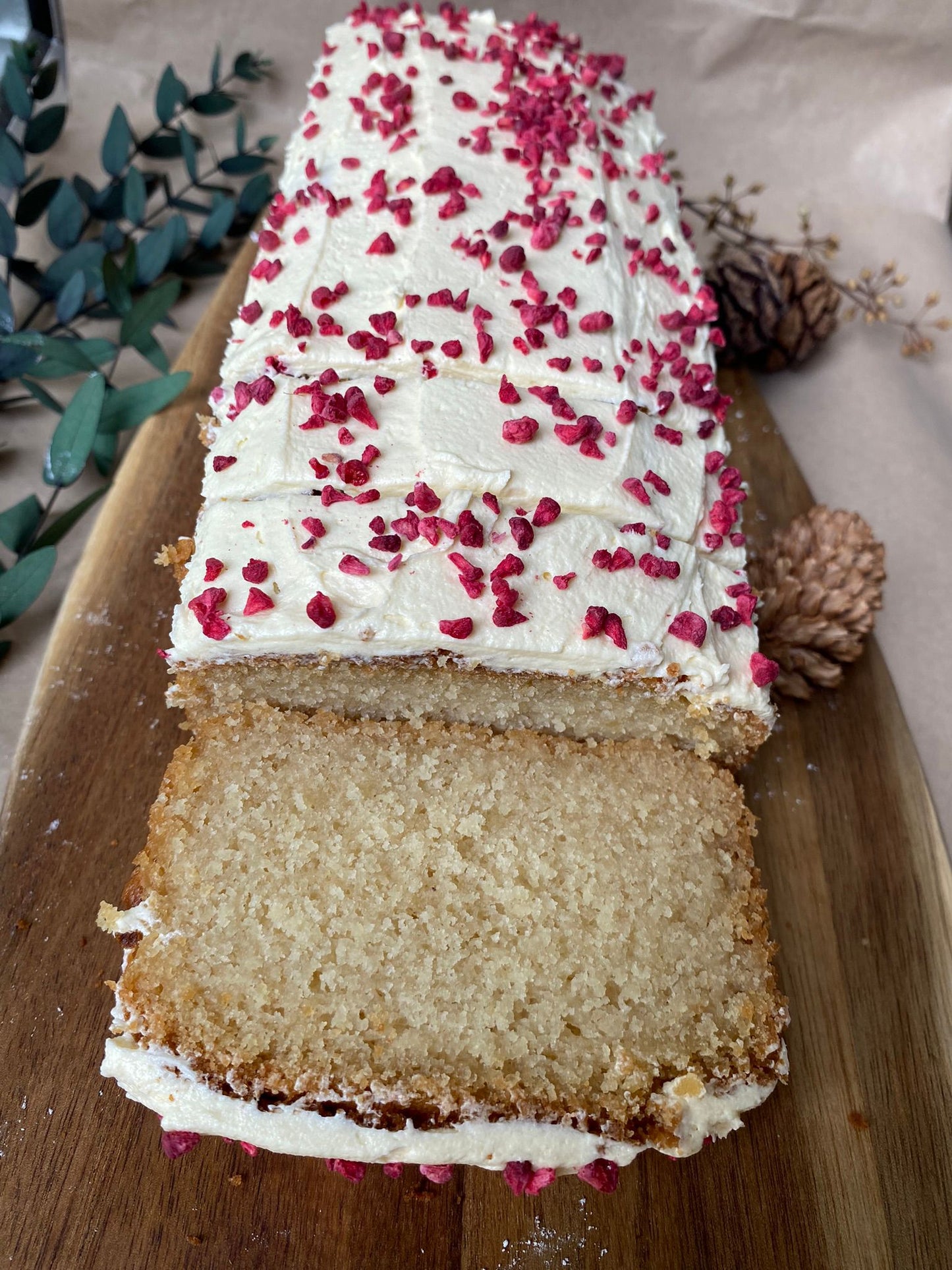 A close-up of a moist vegan lemon drizzle cake, showcasing its fluffy texture and tangy lemon glaze.