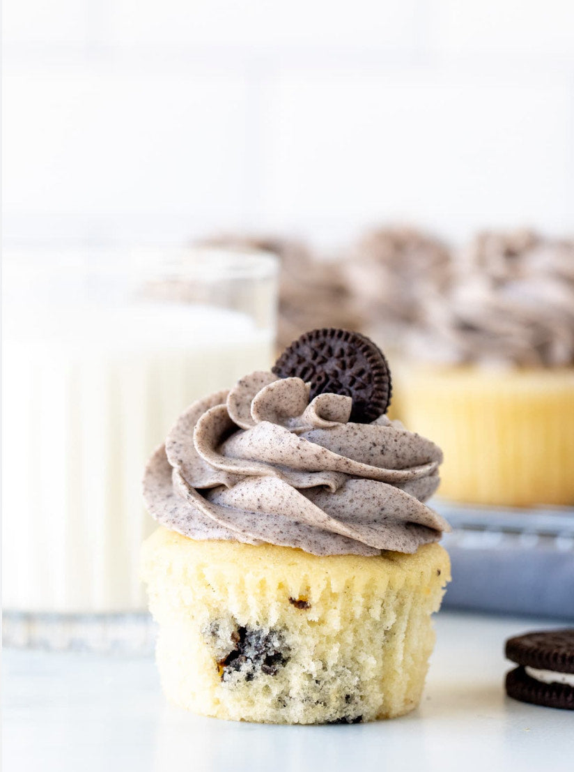 Vegan cookies and cream cupcakes, each topped with a swirl of creamy frosting and crumbled cookies.