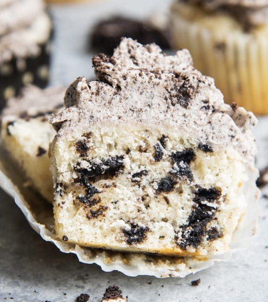 Vegan cookies and cream cupcakes, each topped with a swirl of creamy frosting and crumbled cookies.
