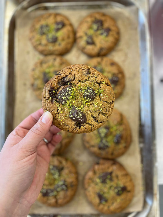 Vegan cookie in Dublin with chunks of dark chocolate and visible salted pistachios.